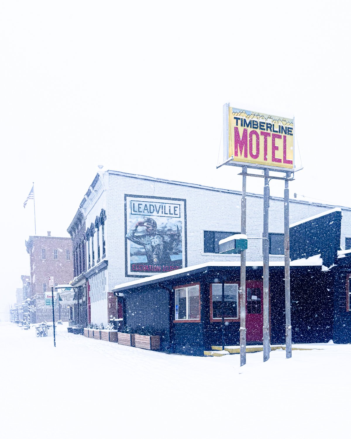 The Timberline Motel sign and the Leadville mural on Harrison Avenue during a snowstorm